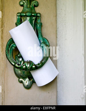 Note left on door knocker Stock Photo