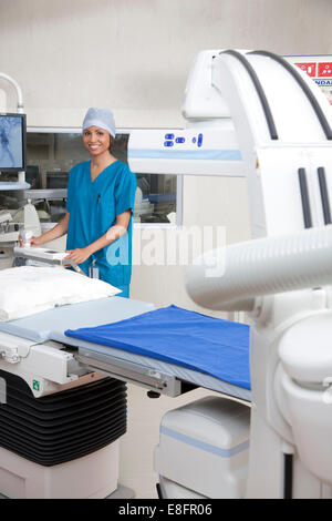 Doctor standing in operating room with robotic imaging system Stock Photo