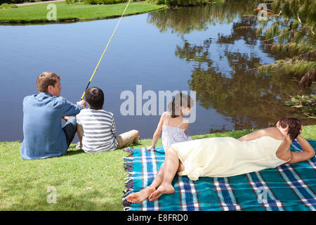 Family sitting by lake fishing, Cape Town, Western Cape, South Africa Stock Photo