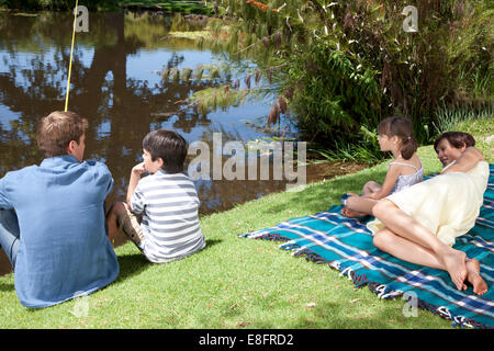 Family sitting by lake fishing, Cape Town, Western Cape, South Africa Stock Photo