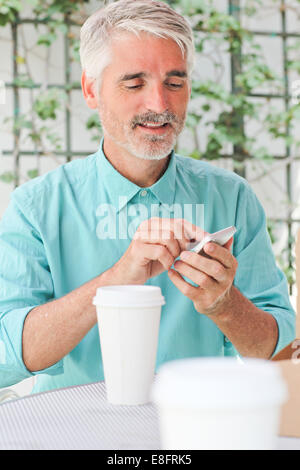Businessman making call in sidewalk cafe Stock Photo