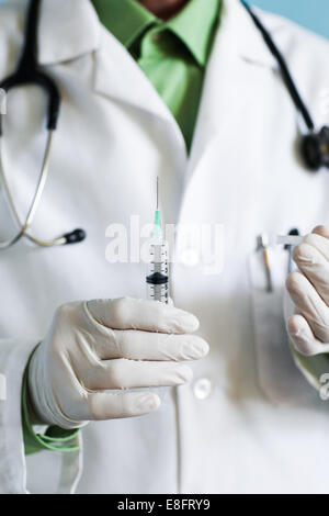 Doctor holding syringe Stock Photo