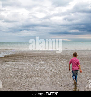 Boy running on the beach Stock Photo