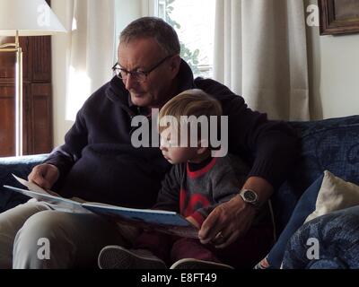 Grandfather and grandson reading book Stock Photo