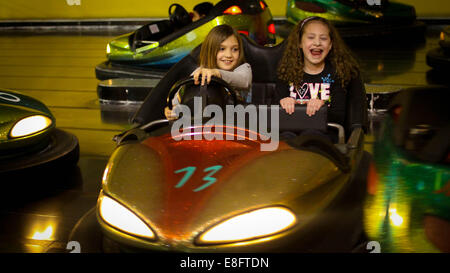 Two girls in bumper cars at a fairground Stock Photo