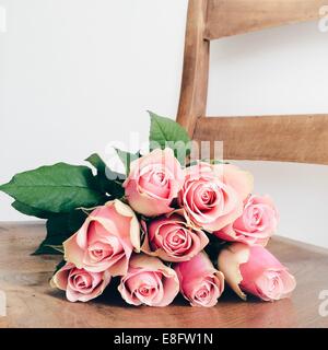 Bouquet of Pink roses lying on chair Stock Photo