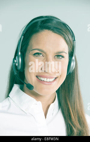Portrait of a smiling businesswoman wearing telephone headset Stock Photo