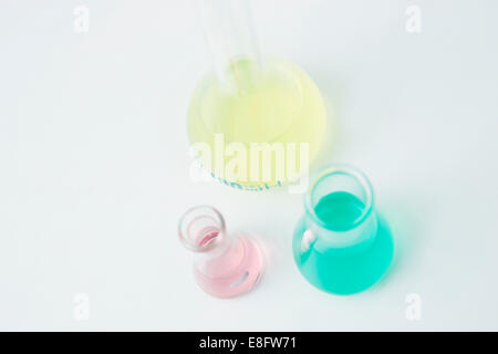 Three conical flasks and measuring beakers in research laboratory Stock Photo