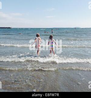 Two children running into the sea, Norway Stock Photo