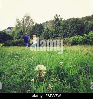 Boy and girl walking in a meadow Stock Photo