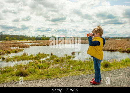 Boy looking through binoculars (4-5 years) Stock Photo