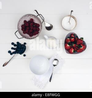 Strawberries, blueberries and raspberries with cream and sugar Stock Photo