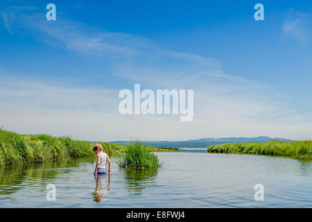 Boy standing in the middle of a lake, USA Stock Photo