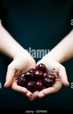 Woman holding a handful of cherries Stock Photo