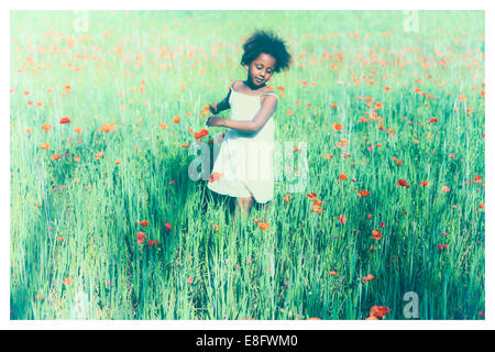 Girls standing in meadow with poppies Stock Photo