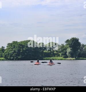 Two girls kayaking on lake Stock Photo
