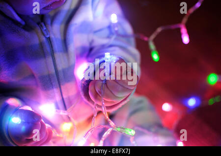 Boy playing with fairy lights Stock Photo