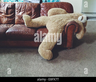 Stuffed teddy bear laying on couch Stock Photo