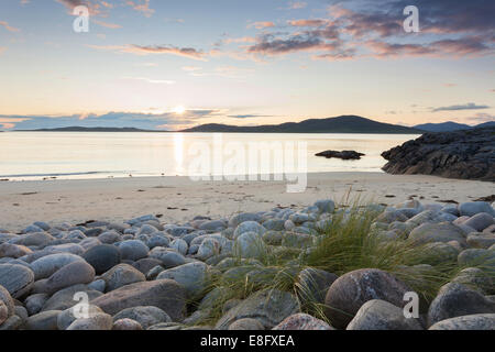 Seilebost beach boulders and sunset over Taransay, Isle of Harris, Outer Hebrides, Scotland Stock Photo
