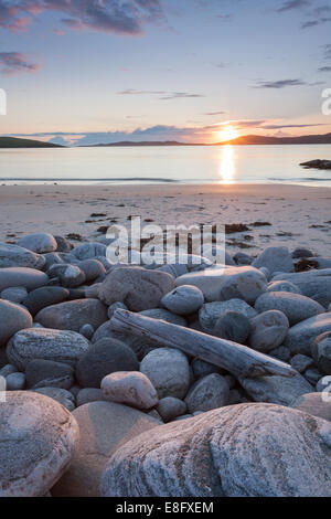 Seilebost beach boulders and sunset over Taransay, Isle of Harris, Outer Hebrides, Scotland Stock Photo