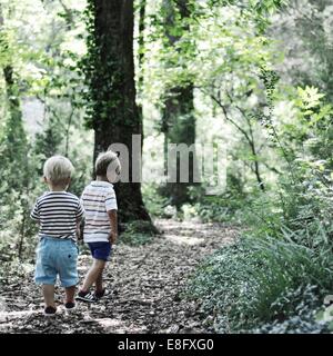 Two boys walking in the woods Stock Photo