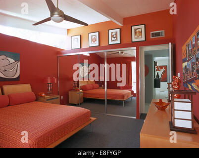 Mirrored doors on fitted wardrobe in modern red bedroom Stock Photo