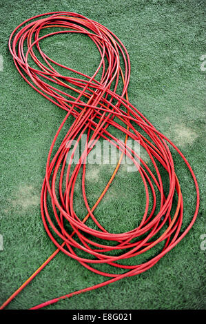 Television red cable coiled on artificial turf Stock Photo