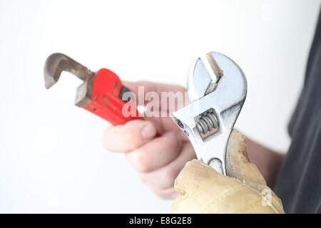 A man holds two different kinds of wrenches. Stock Photo