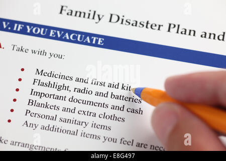 Family Disaster Plan and hand with ballpoint pen. Close-up. Stock Photo