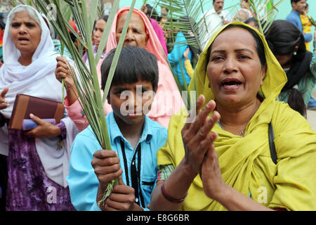 Catholic christian pilgrims march during the Palm Sunday procession through the christian quarter Youhanabad of Lahore, Pakistan Stock Photo