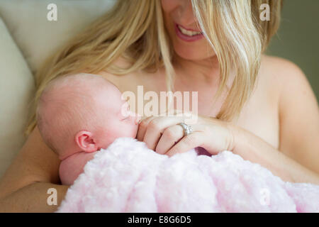 Young Caucasian Beautiful Mother Holding Her Precious Newborn Baby Girl. Stock Photo