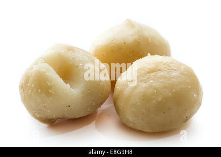 close up of three raw macadamia nuts isolated on a white background Stock Photo