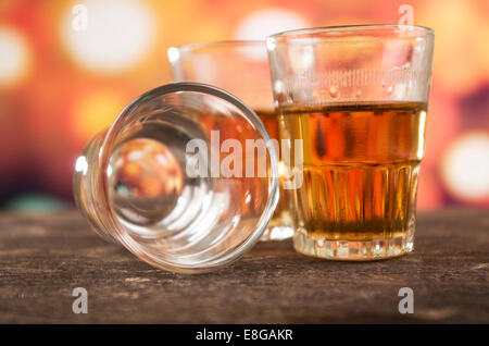 glass of rum whiskey over defocused lights background Stock Photo