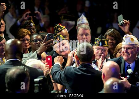 US President Barack Obama greets members of the audience after delivering remarks during the American Legion's 96th National Convention at the Charlotte Convention Center August 26, 2014 in Charlotte, N.C. Stock Photo