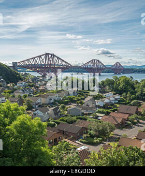 Iconic 19th century cantilever bridge over Firth of Forth with houses of riverbank town of Queenstown in foreground Scotland Stock Photo