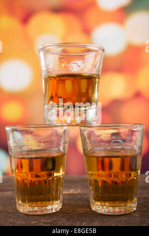 glass of rum whiskey over defocused lights background Stock Photo