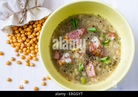 Pea soup with meat in a bowl. Near peas in a sack. Stock Photo