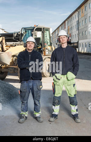 Full length portrait of confident workers standing at construction site Stock Photo