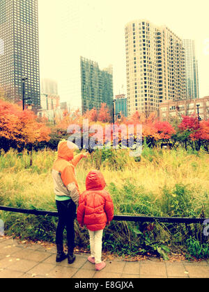 Rear view of two sisters standing in park, Chicago, Illinois, United States Stock Photo