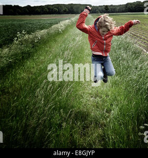 Boy Jumping In a field, Germany Stock Photo