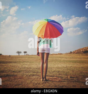 Woman holding a multi coloured Umbrella, Roodepoort, Johannesburg, Gauteng, South Africa Stock Photo