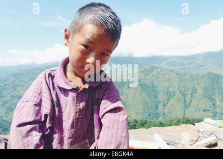 Portrait of a Nepalese boy sitting on a wall, Nepal Stock Photo