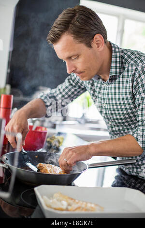 Man preparing fish in kitchen Stock Photo