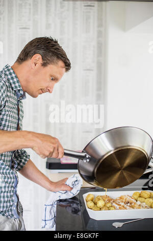 Side view of man preparing food in kitchen Stock Photo