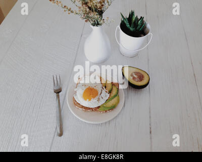 Avocado and fried egg on toast breakfast Stock Photo