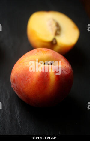 Fresh peach and halved peach Stock Photo