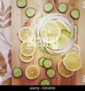 Overhead view of a glass Jar filled With Lemon And cucumber Slices Stock Photo