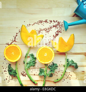 Watering can watering conceptual flowers in a garden Stock Photo