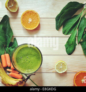 Green smoothie drink next to fresh fruit and vegetable ingredients Stock Photo