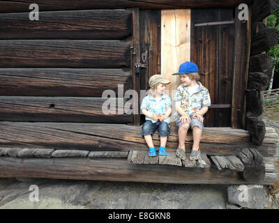 Two boys sitting on porch steps talking Stock Photo